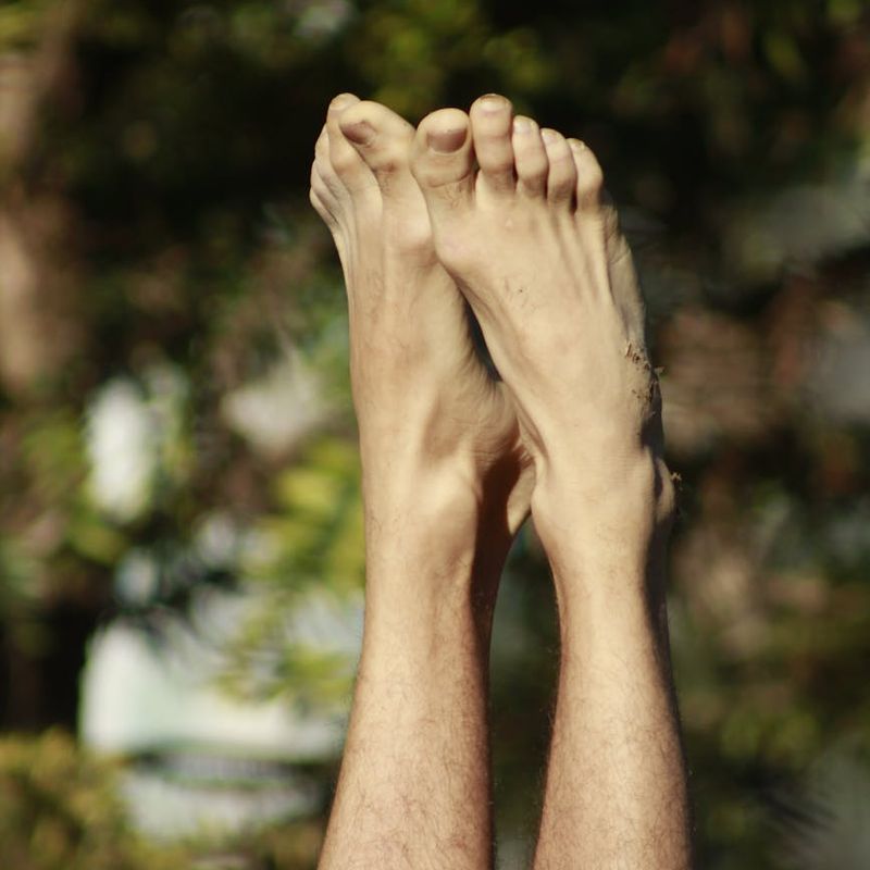 Person balancing on one leg in a yoga tree pose against a minimalist background.